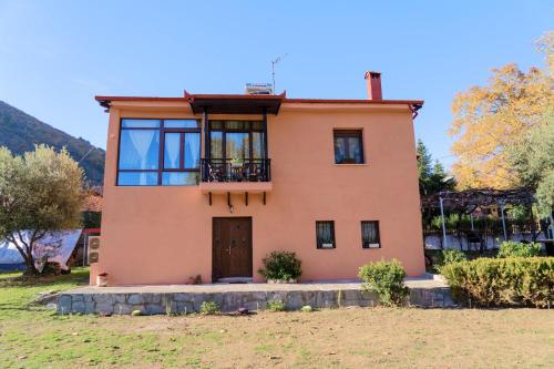 a large pink house with a balcony at Villa Norma in Órma