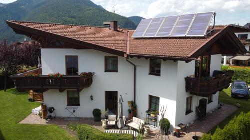 a white house with solar panels on the roof at Haus Albertha in Ehrwald