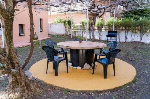 a table with four chairs around it in a yard at Villa Norma in Órma