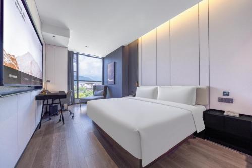 Ένα ή περισσότερα κρεβάτια σε δωμάτιο στο Atour Hotel Emeishan Railway Station Exiu Lake
