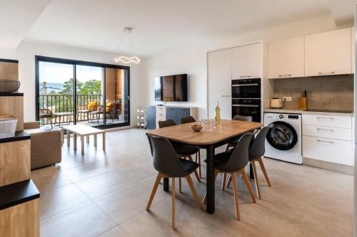 une cuisine et une salle à manger avec une table et des chaises dans l'établissement Appartement T3 Porto Vecchio, à Porto-Vecchio