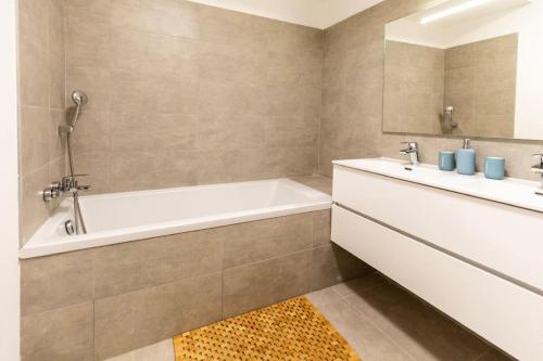 une salle de bain avec une baignoire et un lavabo dans l'établissement Appartement T3 Porto Vecchio, à Porto-Vecchio