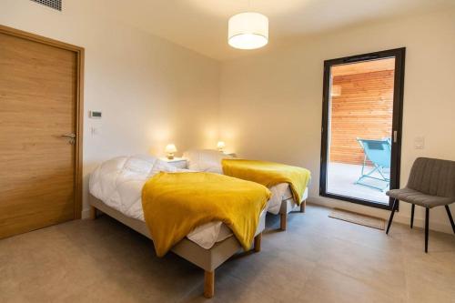 - une chambre avec 2 lits et des couvertures jaunes dans l'établissement Appartement T3 Porto Vecchio, à Porto-Vecchio