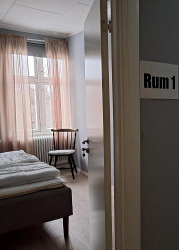 a bedroom with a bed and a window and a chair at Rutsbrogården in Rutån