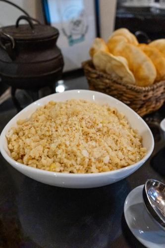 a bowl of rice on a table with baskets of bread at HOTEL CITY in Posadas
