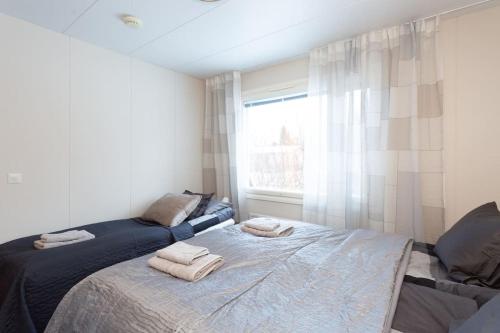 une chambre avec un lit avec des serviettes dessus dans l'établissement Villa Arctic Harmony near SCV, à Rovaniemi