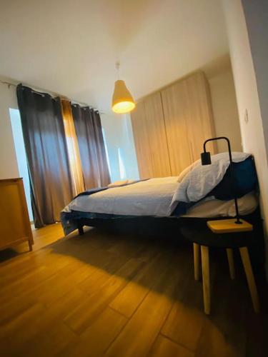 una camera con un letto e una lampada su un pavimento in legno di La casina di Mara & Ilaria a L'Aquila