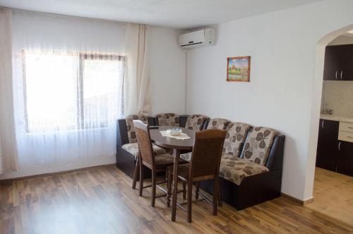 sala de estar con mesa y sofá en Morski Rai Apartments, en Byala