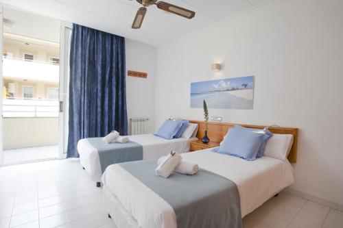 a hotel room with two beds and a window at Apartamento Estándar 3 in Colonia Sant Jordi