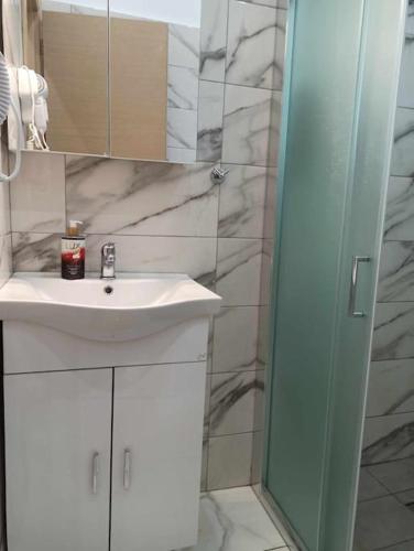a bathroom with a white sink and a mirror at Chios Cozy Apartment 3 in Sklaviá