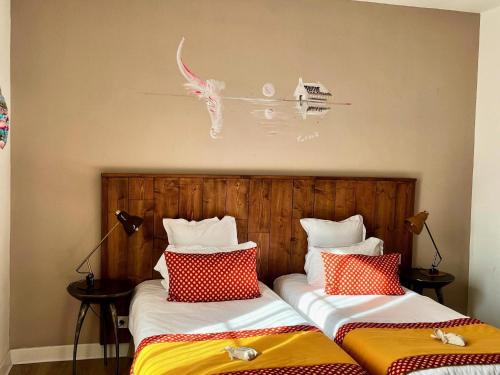 two beds sitting next to each other in a room at Hôtel Saint Louis in Aigues-Mortes