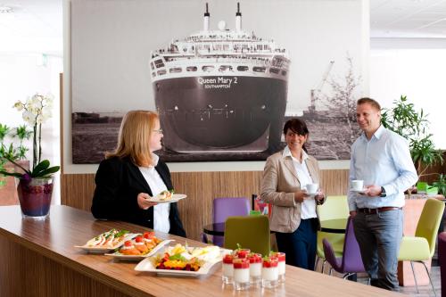 a group of people standing around a table with food at Mercure Hotel Hamburg am Volkspark in Hamburg