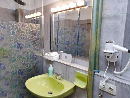 a bathroom with a green sink and a mirror at Deak Ferenc ter Central Apartment in Budapest