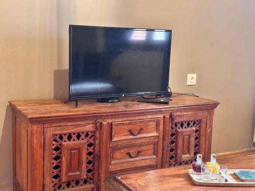 a flat screen tv sitting on top of a wooden entertainment center at Pandoras House Arachova in Arachova