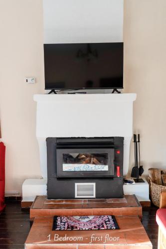 a living room with a fireplace with a tv above it at Villa Norma in Órma