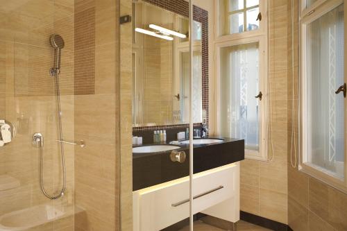 a bathroom with a glass shower and a sink at EA Hotel Atlantic Palace in Karlovy Vary
