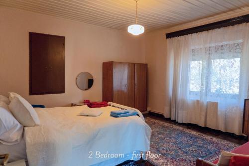 a bedroom with a large bed with a window at Villa Norma in Órma