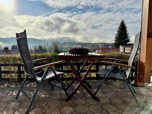 a table with two chairs and a keyboard on a patio at Landhaus Meine Auszeit in Bodenmais