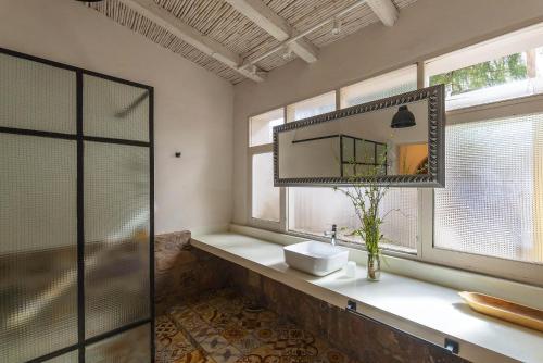 a bathroom with a sink and a mirror and windows at Casa Bernardina in Tilcara