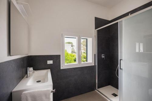a bathroom with a sink and a shower with a window at 4 Bedroom Villa, Private Pool, Marsala in Marsala