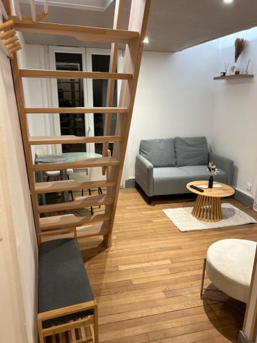 un salon avec un escalier et un canapé dans l'établissement Le Calice - Hypercentre de Reims, à Reims