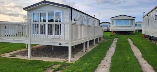 a row of modular homes in a yard with grass at Cayton Bay Holiday Park Kestrel40 in Scarborough