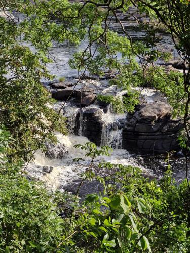a waterfall in the middle of a river at Pousada Canto Feliz in Serra do Cipo