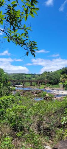 an old train bridge over a river with grass at Pousada Canto Feliz in Serra do Cipo