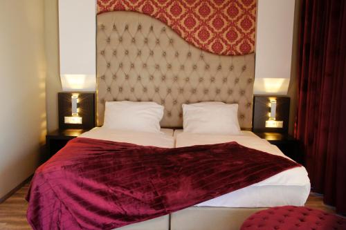 ケルステルバッハにあるHotel Athen Kelsterbach Frankfurt Airportのベッドルーム(紫の毛布を使用した大型ベッド1台付)