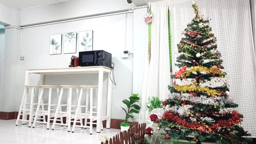 a christmas tree in a room with a fireplace at Apartment near Central Festival Hatyai in Hat Yai