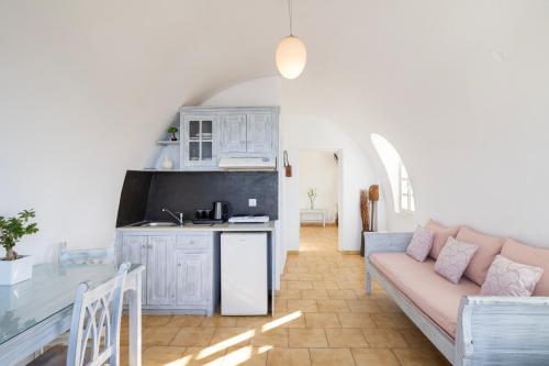 a living room with a couch and a kitchen at Vrachia Studios & Apartments in Oia