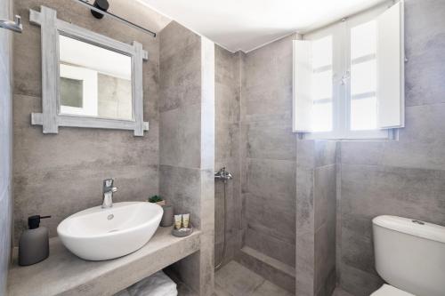 a bathroom with a sink and a shower at Vrachia Studios & Apartments in Oia