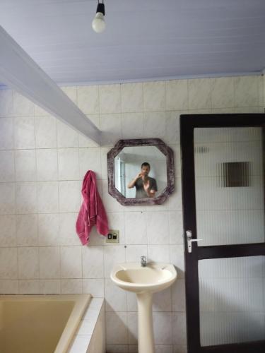 a man taking a picture of a bathroom with a mirror at Cabana na Montanha in Morretes