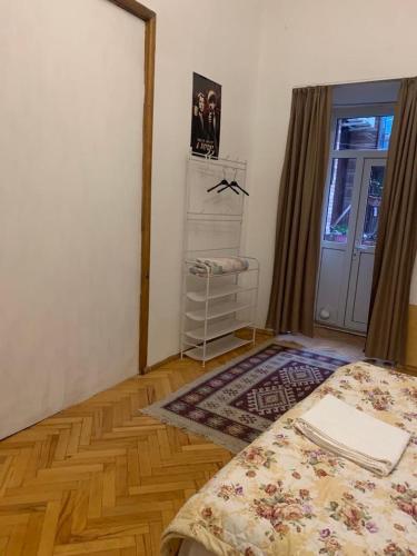 a bedroom with a bed and a window and a door at Leila Apartment in Tbilisi City