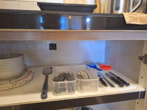 a kitchen counter with utensils on a shelf at Seaput Homes in Ayer Itam