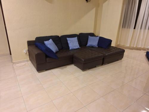 a brown couch with blue pillows in a living room at Seaput Homes in Ayer Itam