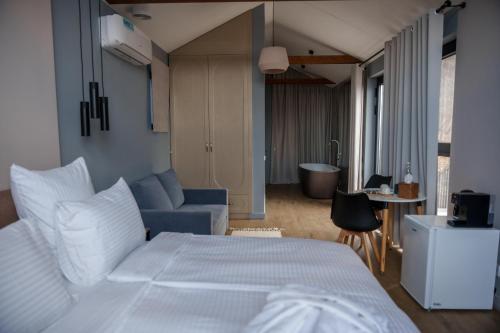 a bedroom with a white bed and a blue couch at Shakaryan Rancho&Restaurant in Dsegh