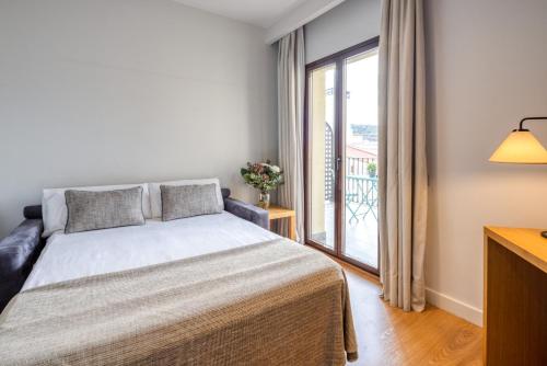 a bedroom with a bed and a large window at Arc La Rambla in Barcelona
