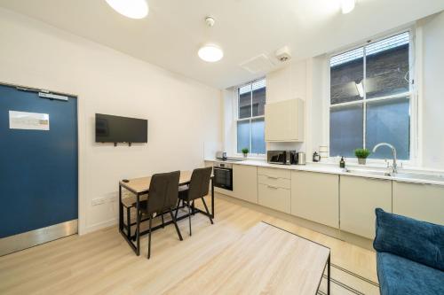 a kitchen with a table and chairs in a room at Clova at Ben More Apartments in Montrose