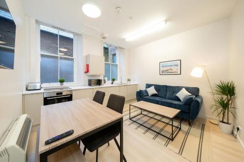 a kitchen and living room with a table and a couch at Clova at Ben More Apartments in Montrose