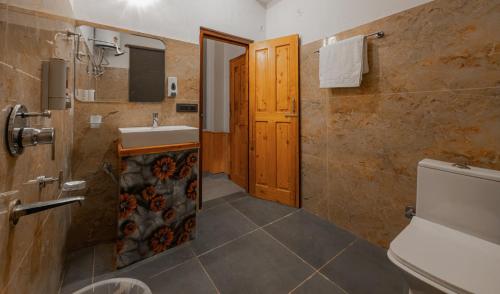 a bathroom with a sink and a toilet at The Rustic Jibhi - Backpackers Hostel in Jibhi