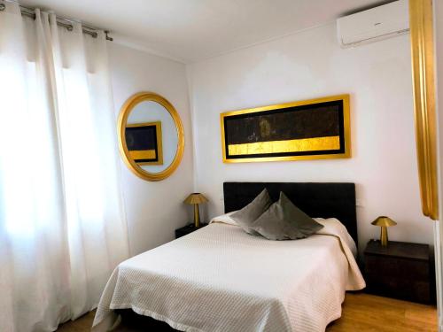 a bedroom with a white bed and a mirror at Appartamento "Laghetto 1" con tre camere e bagni privati cucina in condivisione in Castel San Pietro Terme