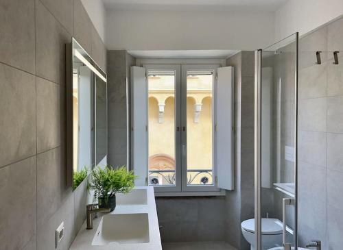 a bathroom with a sink and a toilet and a window at Suite Orione & Andromeda - Pavia City - by Host4U in Pavia