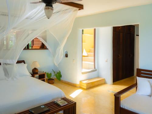a bedroom with two beds and a ceiling fan at Casa Baiana Pousada & Aconchego in Trancoso
