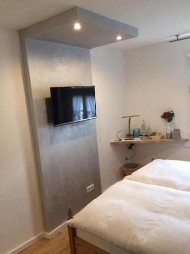 a room with a bed and a tv on a wall at Hotel Haus Mühlbach in Nideggen