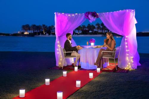 a man and woman sitting at a table under a tent at The Ritz-Carlton, Bahrain in Manama