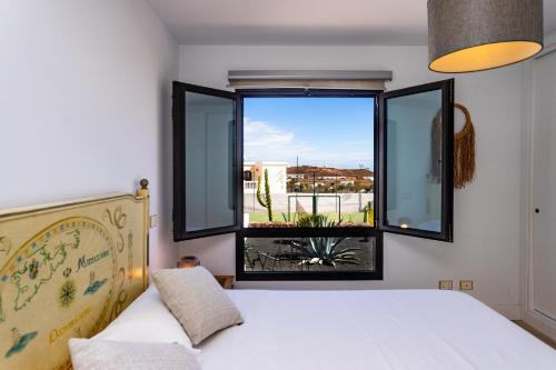 a bedroom with a bed and a large window at Casa Marina in Costa Teguise