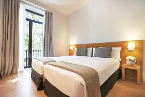 a hotel room with a large bed and a window at Arc La Rambla in Barcelona