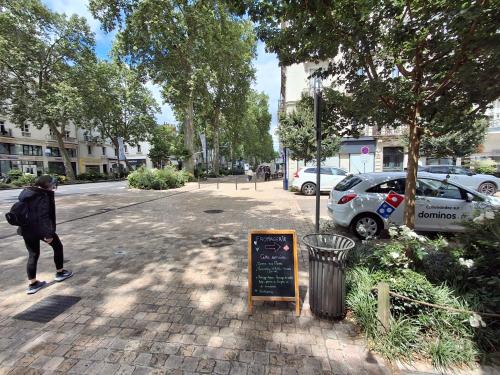 une personne marchant dans la rue à côté d'un panneau dans l'établissement appartement chez Eric 7, à Tours