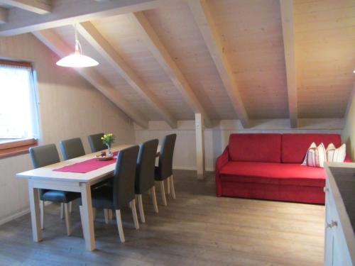 comedor con mesa y sofá rojo en Liebharterhof, en Valdaora